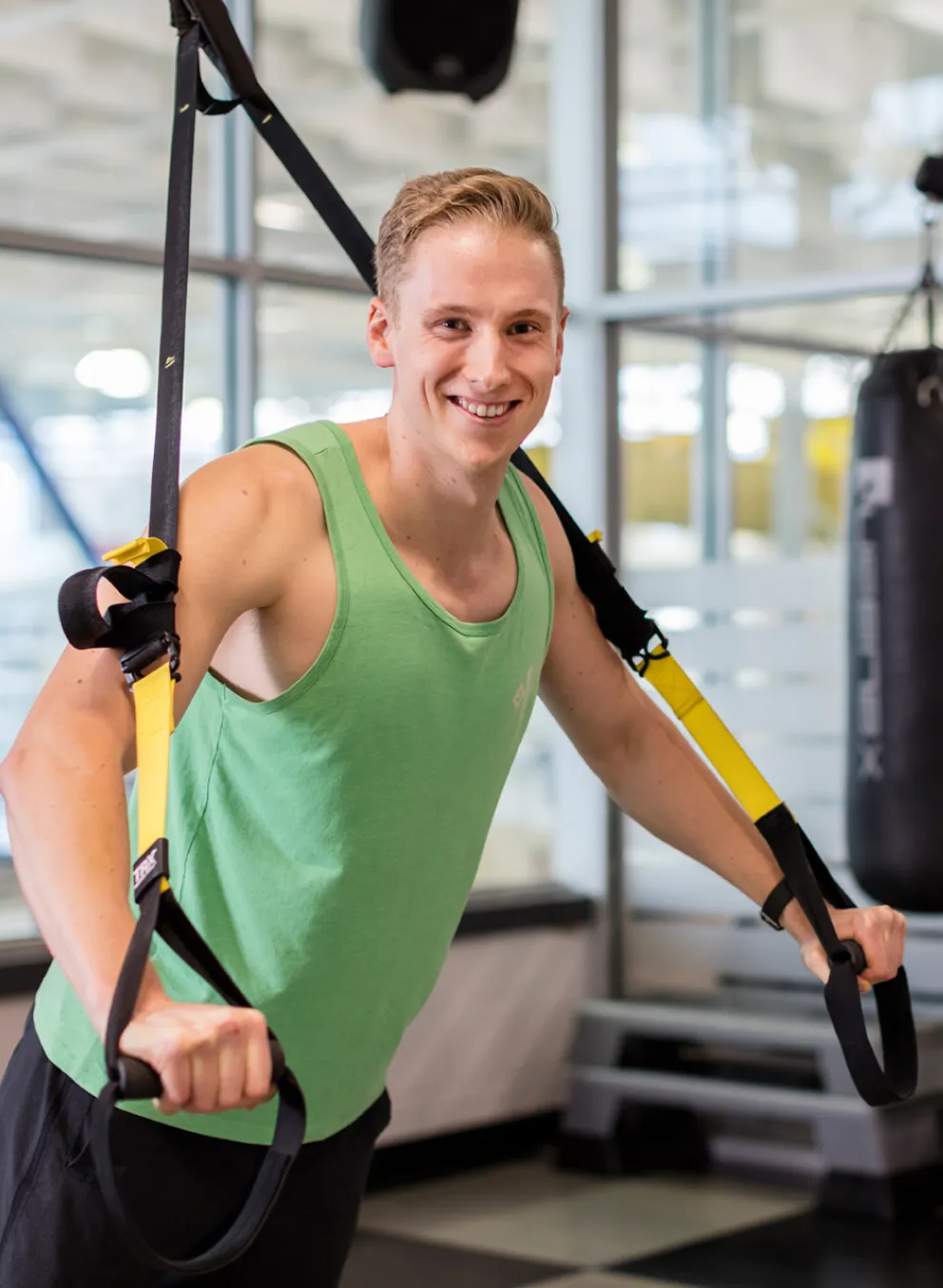 Young man using TRX bands in the studio