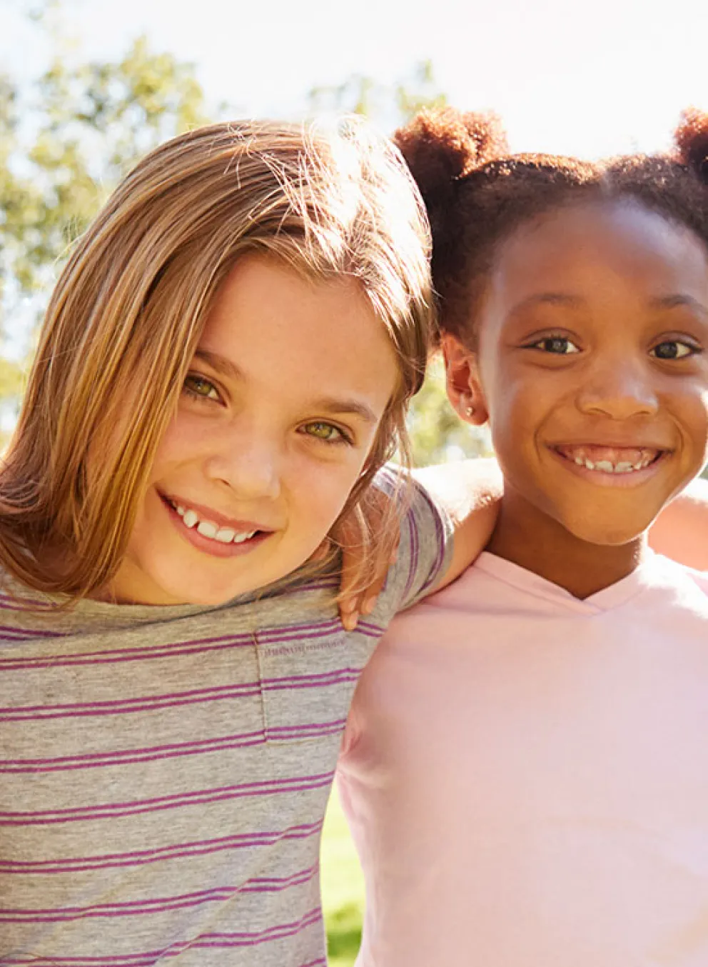 four happy girls outside with soccer ball