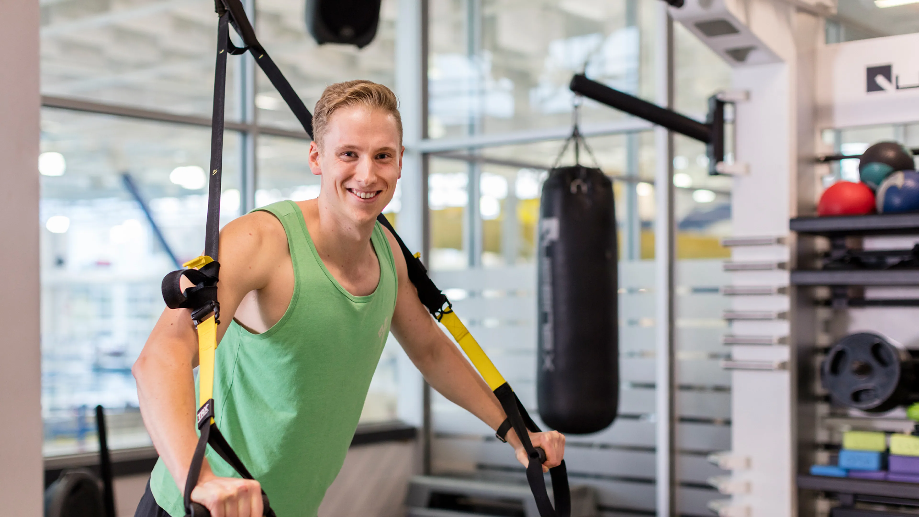 Young man using TRX bands in the studio