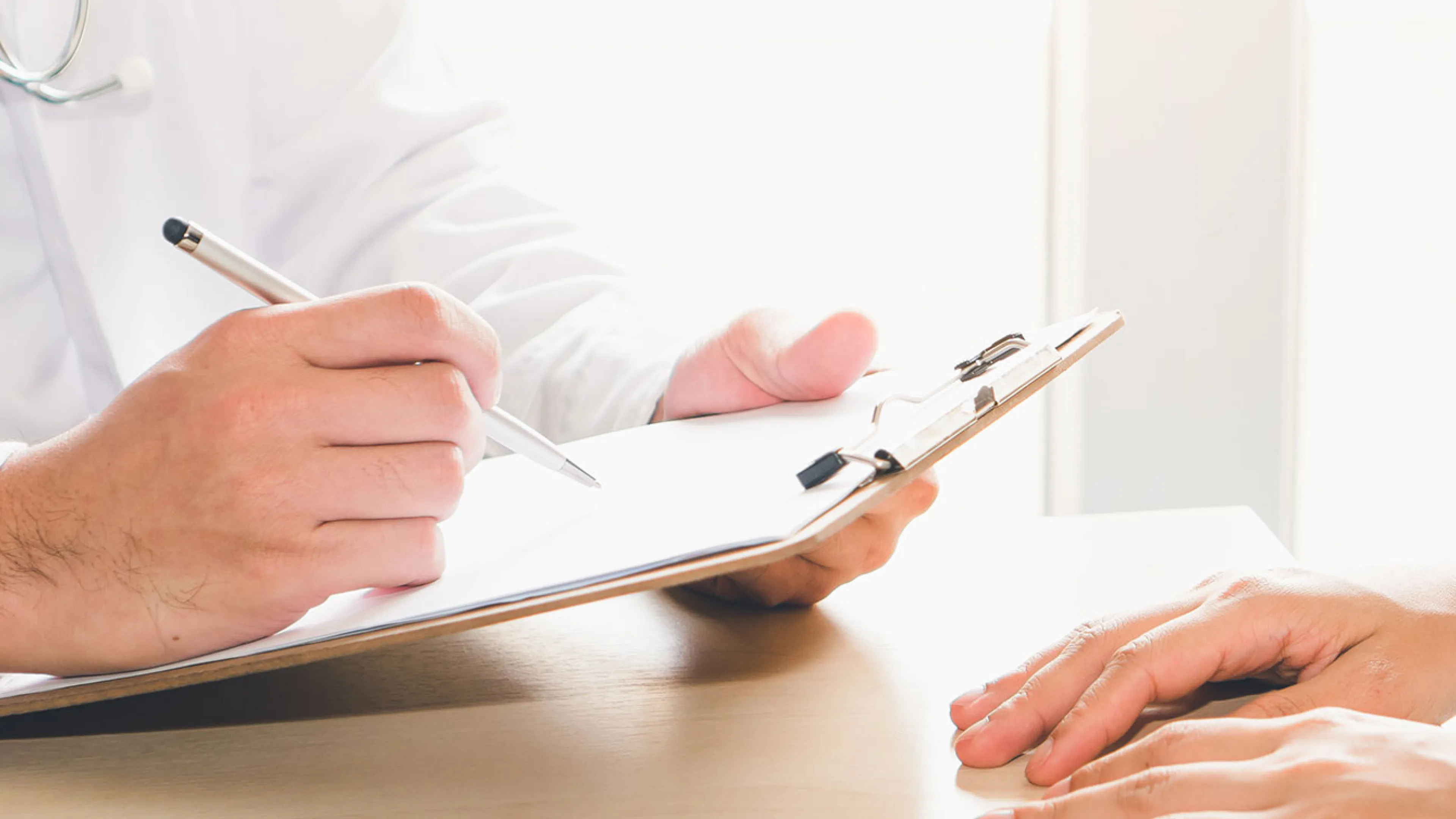 clipboard being written on by doctor