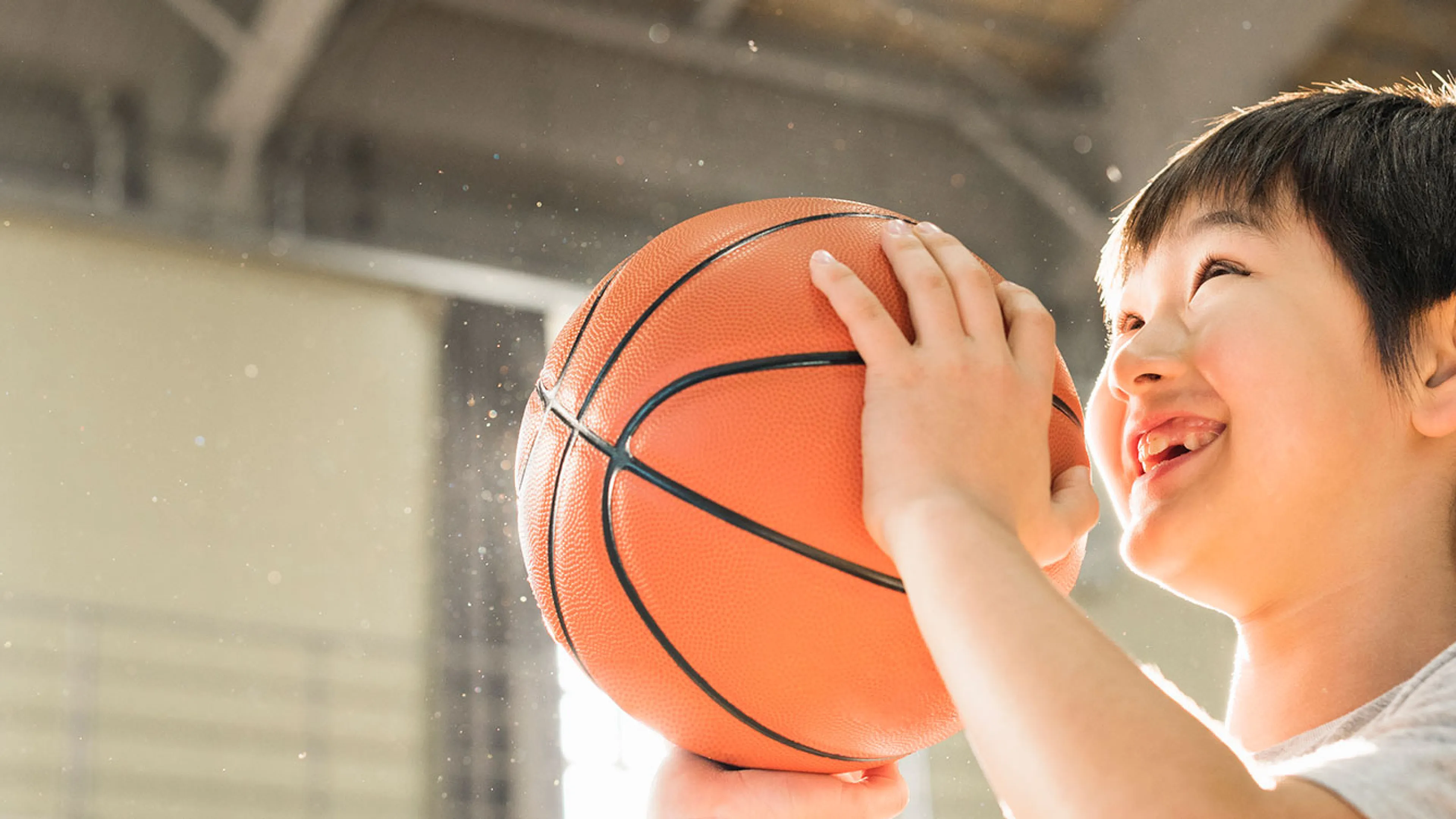 smiling boy preparing to shoot a basketball in the gymnasium