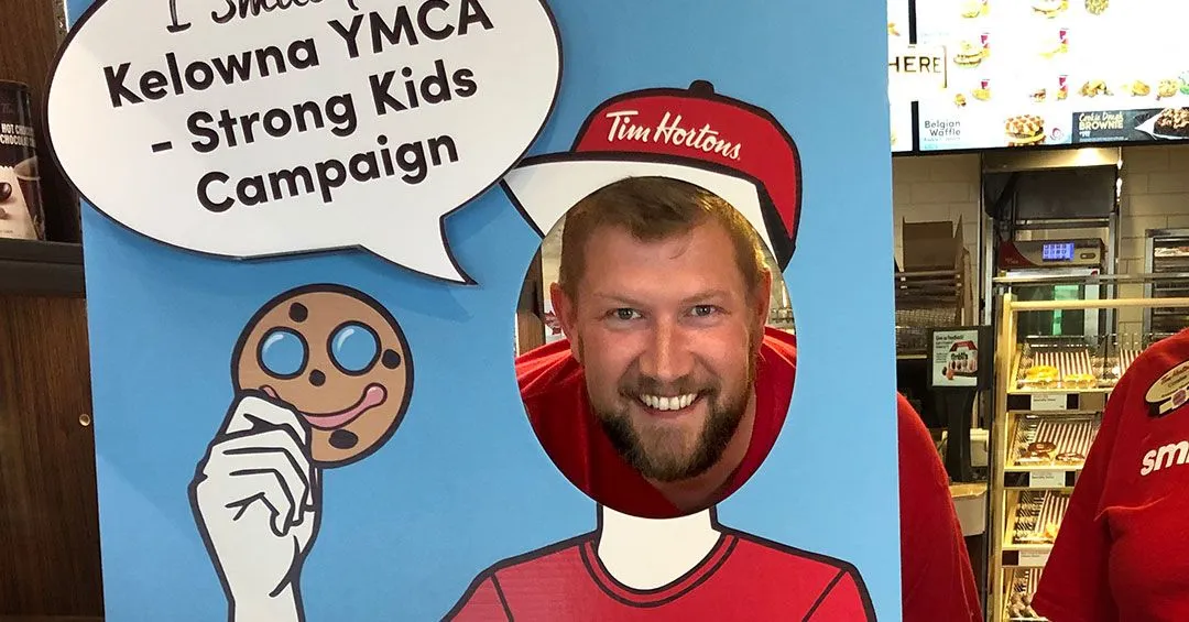 Travis posing behind Smile Cookie themed photo stand-in