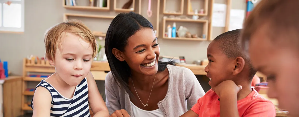 child care worker helping children with shape puzzle